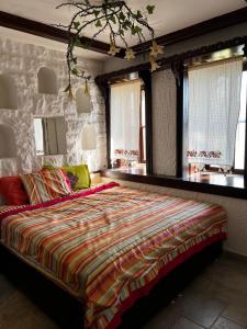 a bedroom with a large bed with a colorful blanket at Escape to History in a Stunning Stone House with Garden and Sea View in the Heart of Alanya in Alanya