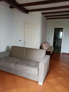 sala de estar con sofá y silla en CANNUBI SAN LORENZO Appartamento-Via Crosia 8 bis-12060-Barolo-Cn, en Barolo