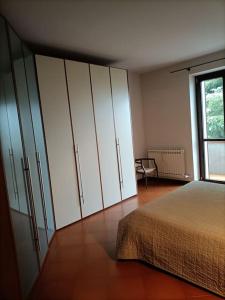 1 dormitorio con cama, armarios y ventana en CANNUBI SAN LORENZO Appartamento-Via Crosia 8 bis-12060-Barolo-Cn, en Barolo