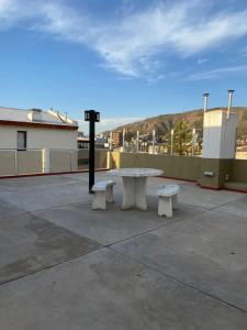 una mesa de picnic y dos bancos en un techo en Edificio Manantiales, en Villa Carlos Paz