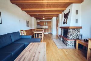 a living room with a blue couch and a fireplace at Pohorje Village Wellbeing Resort - Family Apartments Bolfenk in Hočko Pohorje