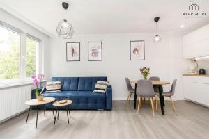 a living room with a blue couch and a table at Old Town by Apartmore in Gdańsk
