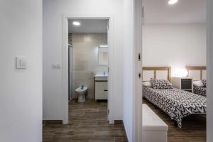 a bedroom with a bed and a bathroom with a sink at Nuevo apartamento en bahia de mazarron a estrenar in Murcia +64 photos