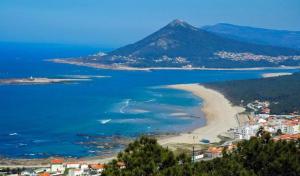 uma vista para uma praia com uma montanha ao fundo em Casa do Mar em Moledo em Moledo