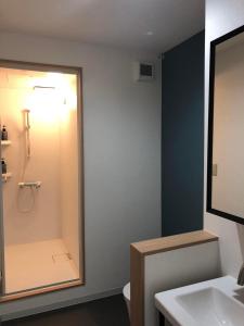 a bathroom with a shower and a toilet and a sink at Hakuba Sunrise Apartments in Hakuba