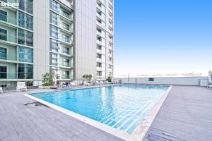 uma piscina ao lado de um edifício em bnbmehomes - Perfect for Corporate Stays with Great Facilities - 2104 em Dubai