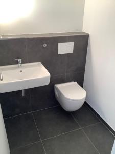 a bathroom with a white sink and a toilet at Ferienwohnung Gabriel in Kirchentellinsfurt