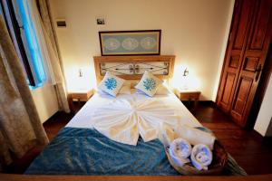 a bedroom with a bed with two towels on it at Aliye Hanim Hotel in Ayvalık