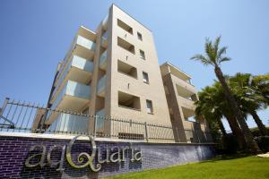 un grand bâtiment avec un palmier devant lui dans l'établissement Ibersol Spa Aqquaria, à Salou