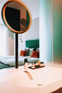- un miroir sur une table dans une chambre avec un lit dans l'établissement Van der Valk Hotel Schiedam, à Schiedam