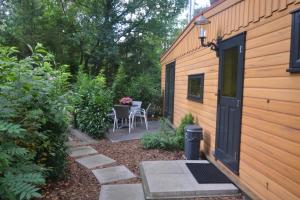 een kleine tuin met een tafel en stoelen naast een gebouw bij VH Wellness Natuurhuisje Het spikkennust in Diever