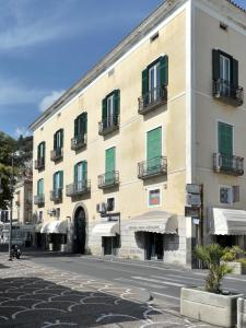 a large building with green shutters on a street at Maiori Dream Rental in Maiori