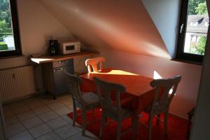 a kitchen with a wooden table and two chairs at Sunshine Apartment 5 in Nidda