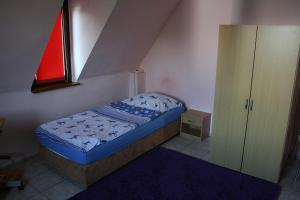 a small bedroom with a bed and a cabinet at Sunshine Apartment 5 in Nidda