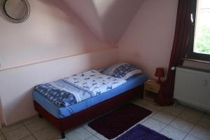 a small bed in a small room with a window at Sunshine Apartment 5 in Nidda
