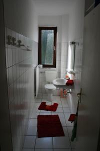 a white bathroom with a sink and a toilet at Sunshine Apartment 5 in Nidda