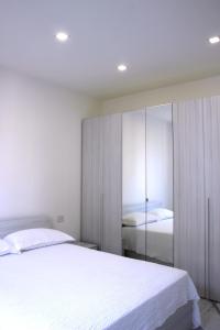 sypialnia z dużym białym łóżkiem i lustrem w obiekcie Dreamich - Scavi Romani w mieście Desenzano del Garda