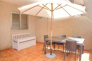 einen Tisch und Stühle mit Sonnenschirm in einem Zimmer in der Unterkunft Navy Apartment, El Poris in Arico