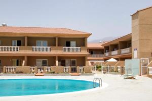 ein Hotel mit einem Pool vor einem Gebäude in der Unterkunft Navy Apartment, El Poris in Arico