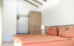 ツェルマットにあるハウス メリーランドのベッドルーム1室(オレンジ色の枕が付いた大きなオレンジ色のベッド1台付)