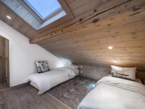 two beds in a room with wooden ceilings at Superbe duplex central à Méribel pour 8 pers, proche pistes - FR-1-565-16 in Les Allues