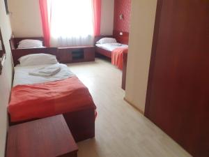 um pequeno quarto com 2 camas e uma janela em Gościniec Zodiac em Rzuchów