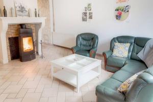 ein Wohnzimmer mit 2 Sofas und einem Kamin in der Unterkunft Gîte de l'Etrier 3 * : Le calme à la campagne ! in Aubercy