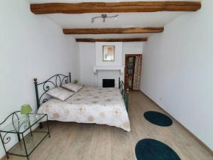 ein Schlafzimmer mit einem großen Bett und einem Kamin in der Unterkunft Gîte de l'Etrier 3 * : Le calme à la campagne ! in Aubercy