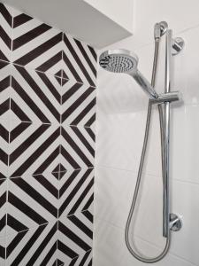 een douche in een badkamer met zwarte en witte tegels bij Design loft Rosella Home Sorrento in Piano di Sorrento