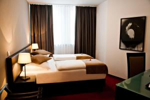 a hotel room with two beds and a window at The Corner Hotel in Frankfurt