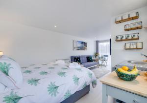 a bedroom with a bed and a table with a bowl of fruit at Idrella Studio in Saltdean