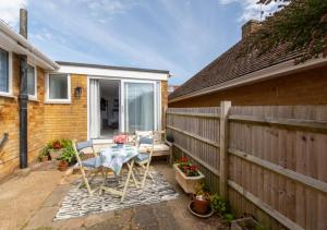a patio with a table and chairs and a fence at Idrella Studio in Saltdean