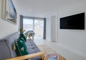 a living room with a couch and a tv at Idrella Studio in Saltdean