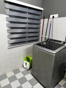 a trash can in a bathroom with a tile floor at You&Me Corner Lot Homestay 17PAX in Port Dickson