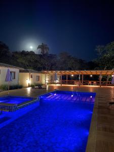 una piscina iluminada por la noche en Pousada Villa Recanto dos Lagos, en Brumadinho