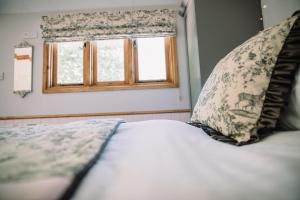 a bed with two pillows and a window at Snowdrop Lodge, Walcot Hall Estate in Alkborough