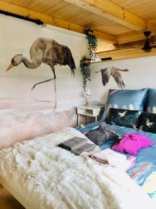 - une chambre avec un lit orné d'une peinture murale représentant un oiseau dans l'établissement Czaplowisko - domki z sauną na Kaszubach, à Stare Czaple