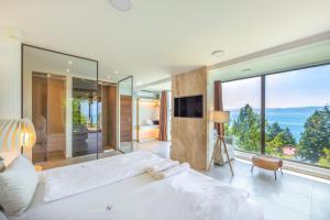 a bedroom with a large bed and a large window at Vila Bisera in Ohrid
