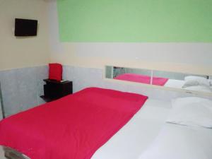 ein Schlafzimmer mit einem weißen Bett mit einer roten Decke in der Unterkunft Hotel Lendosis Mayor Ruslan in Palembang
