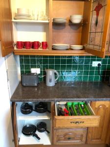 a kitchen counter with a stove and some plates at 5/6 Bed House Barnsley Centre in Barnsley