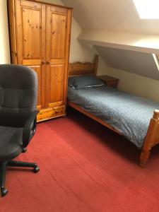 1 dormitorio con cama, escritorio y silla en 5/6 Bed House Barnsley Centre, en Barnsley