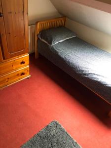 a bedroom with two beds and a dresser and red carpet at 5/6 Bed House Barnsley Centre in Barnsley