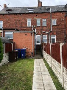 una casa de ladrillo con una valla y un patio en 5/6 Bed House Barnsley Centre en Barnsley