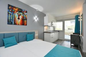 a bedroom with a large bed and a kitchen at City-Hotel Zuffenhausen in Stuttgart