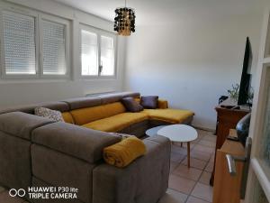 a living room with a couch and a table at Bain de soleil in Forcalquier