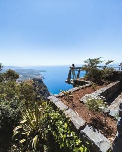 een persoon op een klif met uitzicht op de oceaan bij Getaway to Blue Paradise at Madeira Island in Funchal