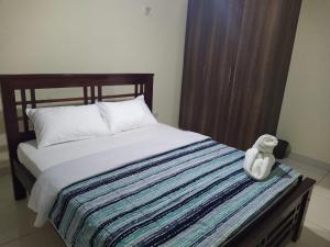 a teddy bear sitting on top of a bed at Amohela Serviced Apartments - Kisumu in Mamboleo