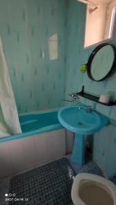ein Badezimmer mit einem Waschbecken, einem Spiegel und einer Badewanne in der Unterkunft Umid Hostel in Buxoro