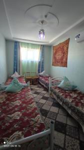 a room with two beds and a window at Umid Hostel in Bukhara