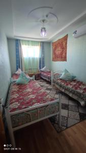 a bedroom with two beds and a window at Umid Hostel in Bukhara